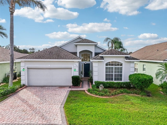 235 Royal Palm Dr, Davenport, FL 33837 - view of front of property featuring stucco siding, decorative driveway, a garage, and a front lawn