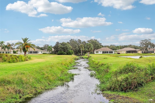 surrounding community featuring a water view and a yard