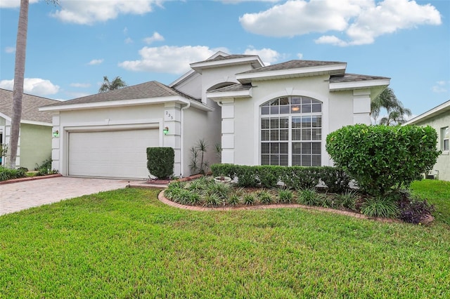 235 Royal Palm Dr, Davenport, FL 33837 - view of front of home featuring a garage, decorative driveway, a front yard, and stucco siding