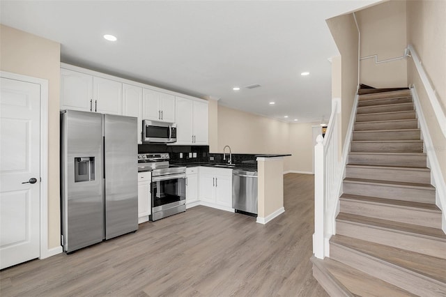 kitchen featuring white cabinetry, appliances with stainless steel finishes, and light hardwood / wood-style floors