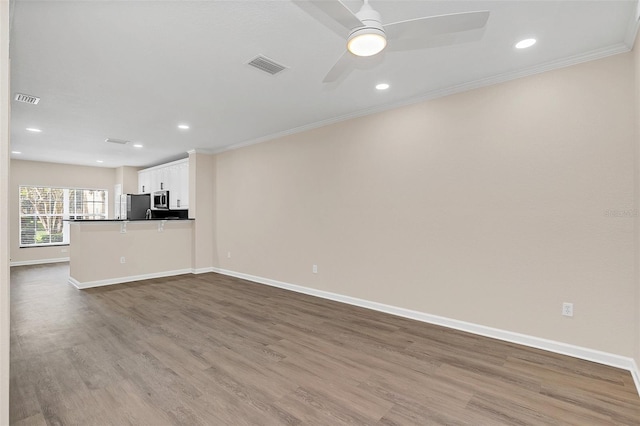 unfurnished living room featuring ceiling fan, light hardwood / wood-style flooring, and ornamental molding