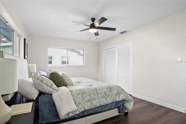 bedroom with dark hardwood / wood-style flooring, ceiling fan, and a closet