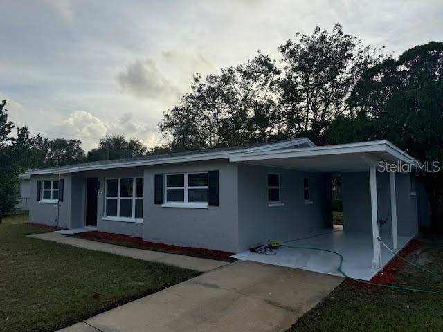 ranch-style home featuring a front lawn and a carport