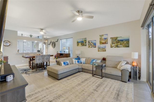 living room with ceiling fan and light hardwood / wood-style floors