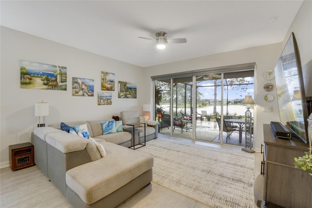 living room featuring ceiling fan and light hardwood / wood-style floors