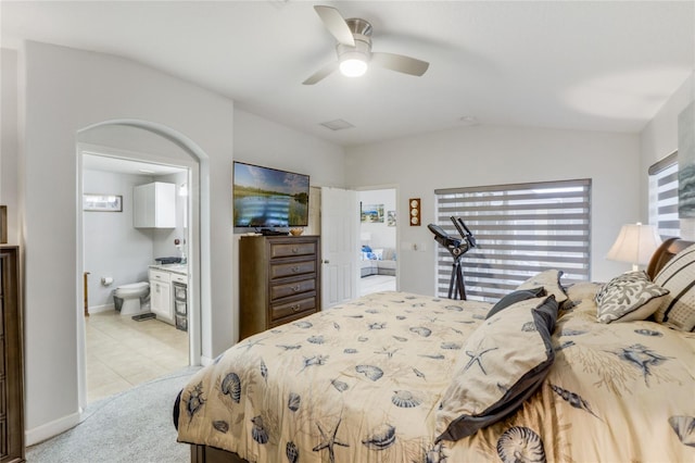 tiled bedroom with ensuite bathroom, vaulted ceiling, and ceiling fan