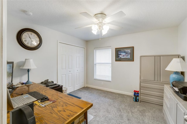 carpeted office space with ceiling fan and a textured ceiling