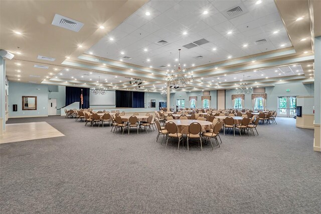 dining room with a raised ceiling, carpet floors, and crown molding