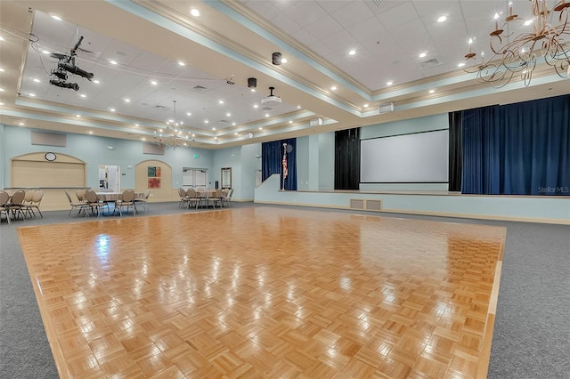 interior space featuring a raised ceiling, a towering ceiling, ornamental molding, and a notable chandelier