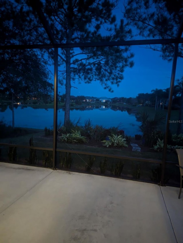 patio terrace at dusk featuring a water view