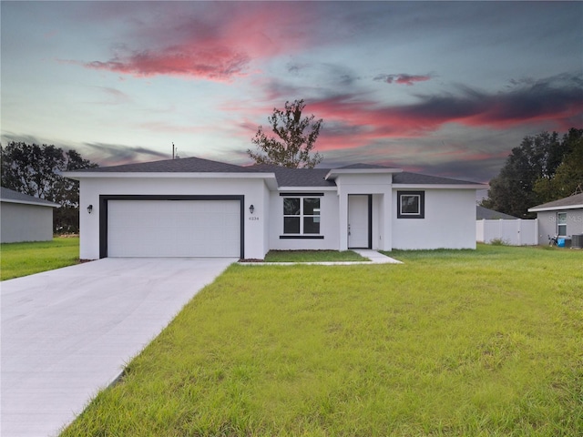 ranch-style house with a garage and a lawn