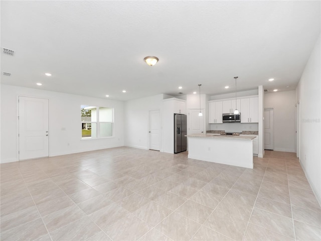 kitchen featuring white cabinetry, appliances with stainless steel finishes, light tile patterned floors, an island with sink, and pendant lighting