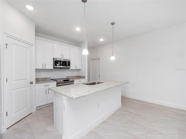 kitchen featuring appliances with stainless steel finishes, light stone countertops, hanging light fixtures, an island with sink, and white cabinets