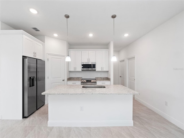 kitchen with appliances with stainless steel finishes, hanging light fixtures, a center island with sink, and white cabinets