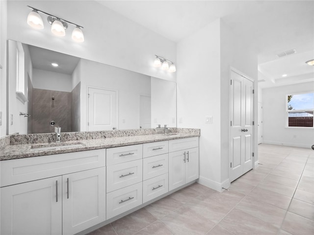 bathroom featuring walk in shower, vanity, and tile patterned flooring