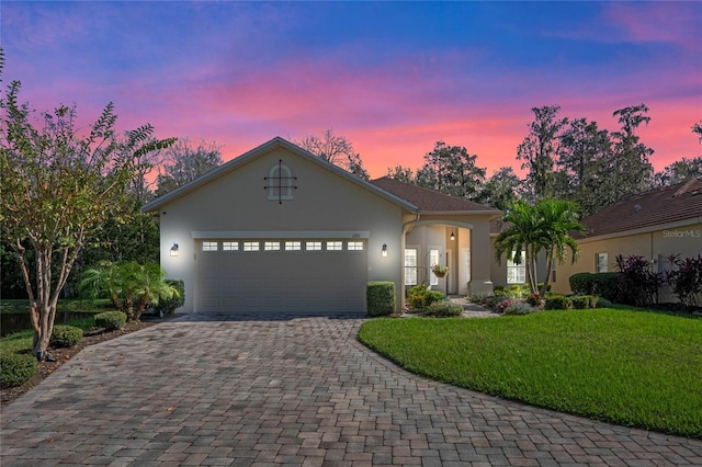 view of front of home with a garage and a lawn