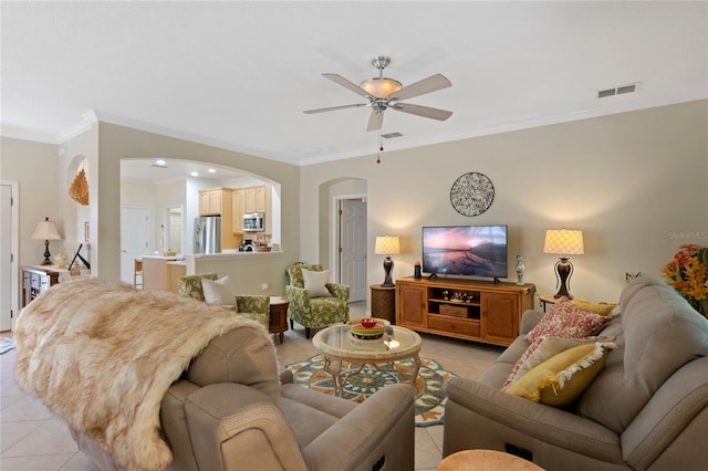 tiled living room with ornamental molding and ceiling fan