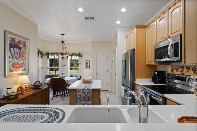 kitchen with a textured ceiling, ornamental molding, hanging light fixtures, and appliances with stainless steel finishes