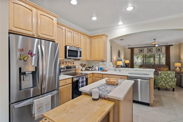 kitchen with kitchen peninsula, appliances with stainless steel finishes, crown molding, and light brown cabinets