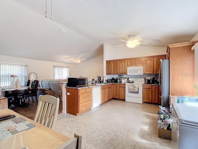 kitchen featuring kitchen peninsula, lofted ceiling, ceiling fan, and appliances with stainless steel finishes