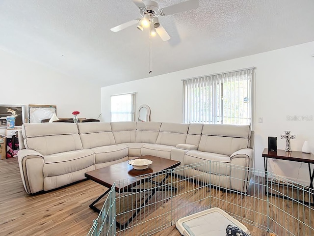 5 Oak Trl, Ocala, FL 34472 - living area featuring wood finished floors, a textured ceiling, a ceiling fan, and vaulted ceiling