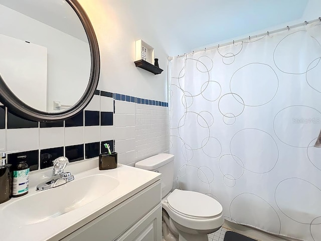 bathroom featuring vanity, toilet, and tile walls