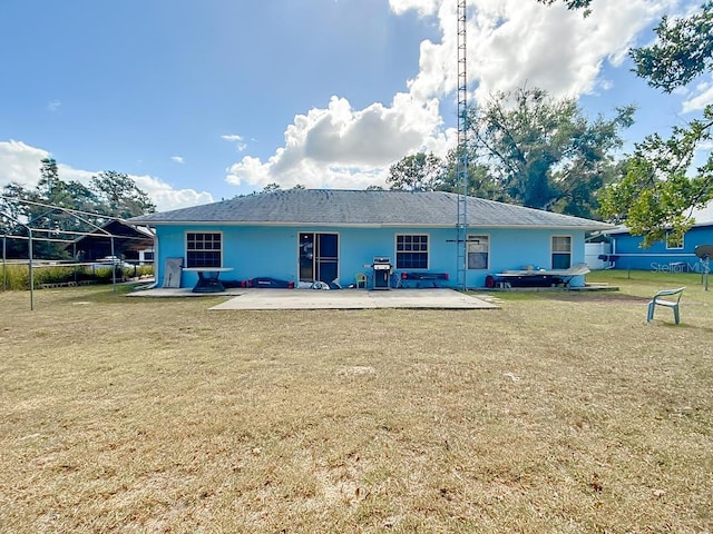 rear view of property featuring a yard and a patio area