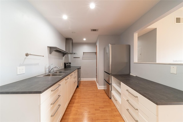 kitchen with stainless steel appliances, white cabinets, sink, and light wood-type flooring