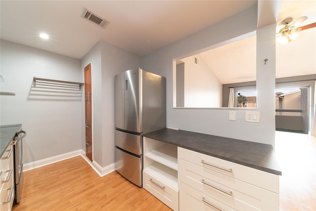 kitchen with light hardwood / wood-style floors, white cabinetry, and appliances with stainless steel finishes