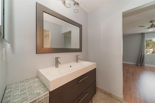 bathroom featuring vanity, hardwood / wood-style floors, ceiling fan, and a textured ceiling