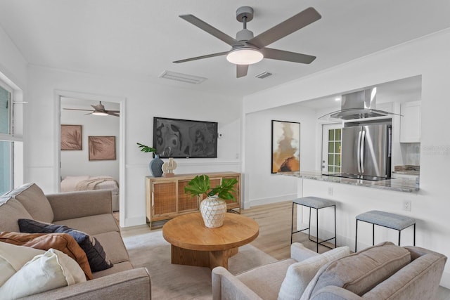 living room featuring light hardwood / wood-style flooring and ceiling fan