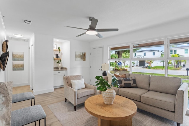 living room with light hardwood / wood-style flooring and ceiling fan