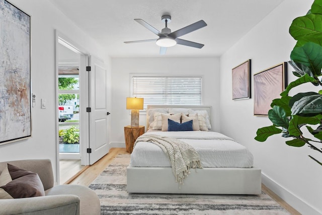 bedroom with light hardwood / wood-style floors, multiple windows, and ceiling fan