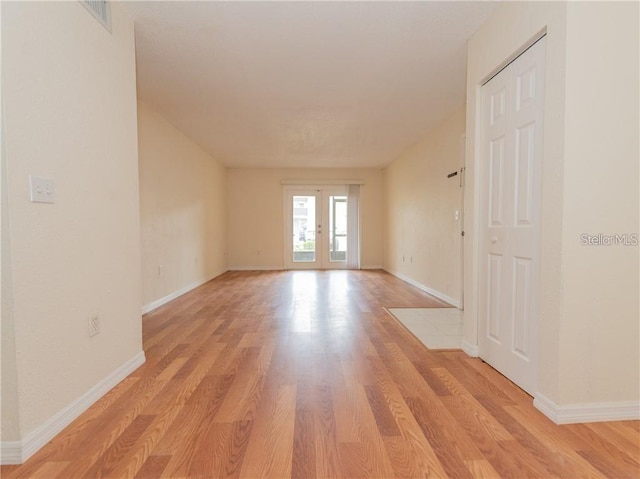 unfurnished room with light hardwood / wood-style floors and french doors