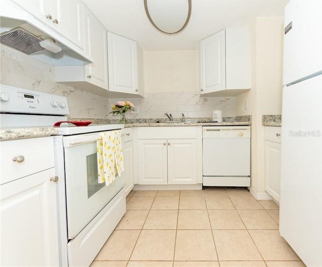 kitchen with white appliances, light tile patterned flooring, and white cabinets