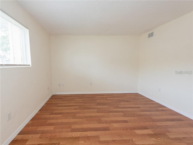 unfurnished room with hardwood / wood-style flooring