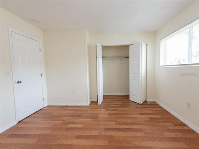 unfurnished bedroom featuring a closet and wood-type flooring