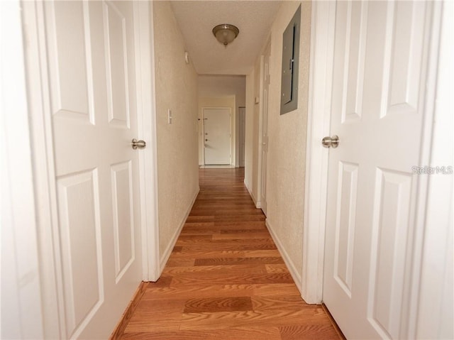 hallway featuring electric panel and hardwood / wood-style flooring