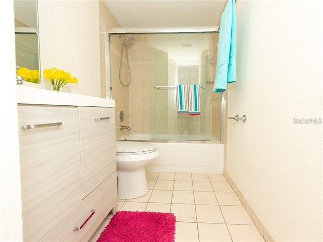 full bathroom with toilet, tiled shower / bath combo, vanity, and tile patterned flooring