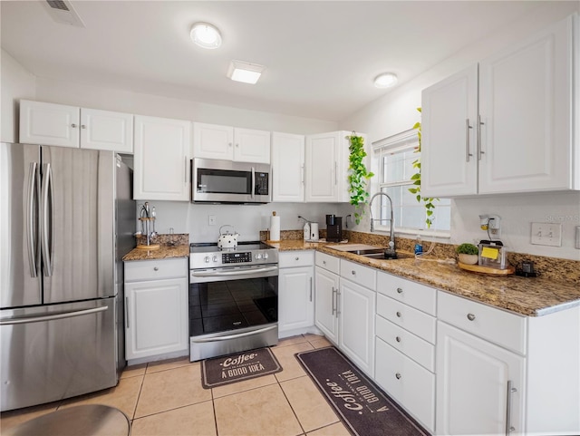 kitchen with white cabinetry, sink, light tile patterned flooring, and appliances with stainless steel finishes