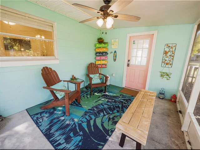 sitting room featuring ceiling fan and concrete floors