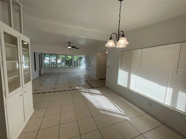 interior space with ceiling fan with notable chandelier, light tile patterned floors, and plenty of natural light