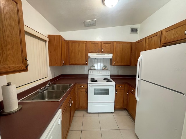 kitchen featuring sink, light tile patterned floors, white appliances, lofted ceiling, and decorative backsplash