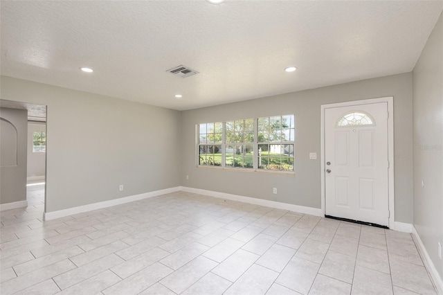 foyer entrance with a textured ceiling