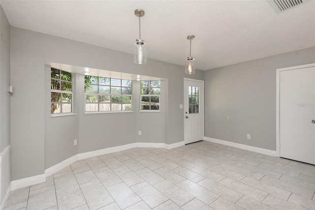 tiled spare room featuring a textured ceiling