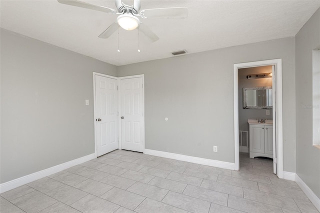 unfurnished bedroom featuring ceiling fan, connected bathroom, and light tile patterned floors