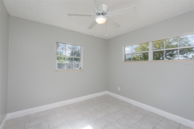 tiled spare room featuring a textured ceiling and ceiling fan