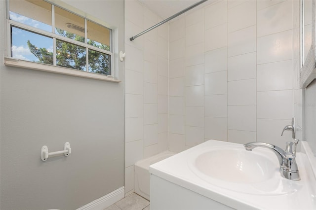 bathroom with tiled shower / bath, sink, and tile patterned flooring