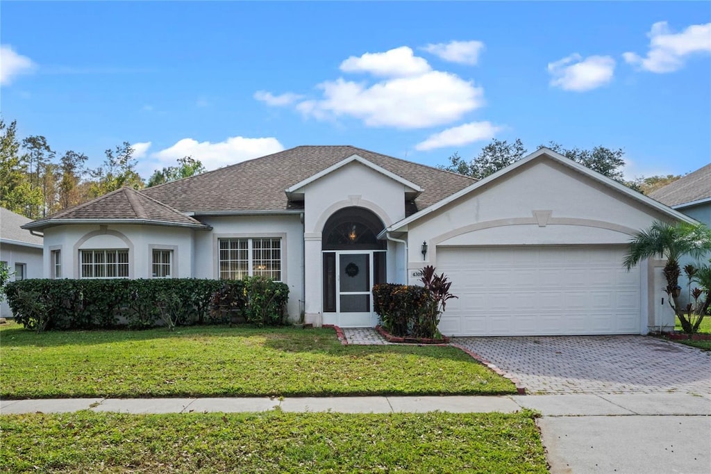 ranch-style house with a garage and a front yard