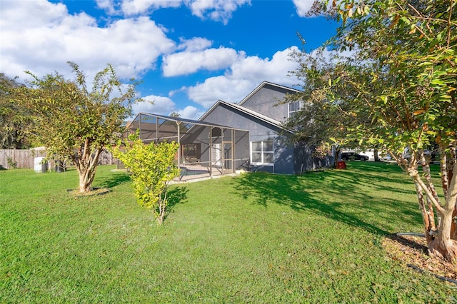 back of property featuring a swimming pool, glass enclosure, and a lawn